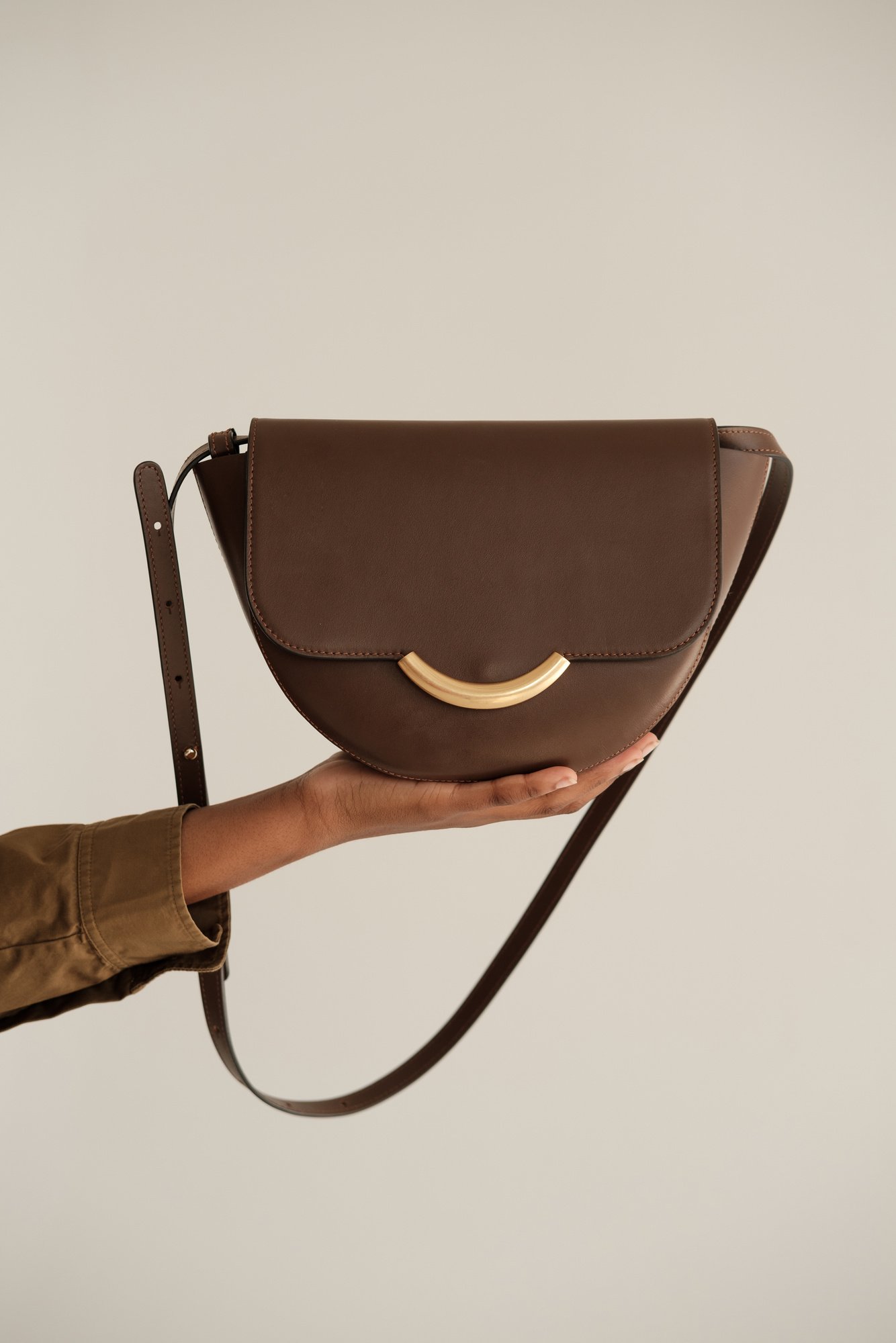 Hand Holding Brown Handbag